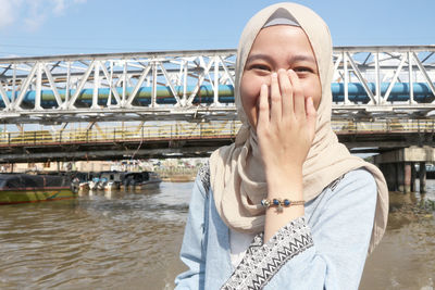 Portrait of young woman against built structure