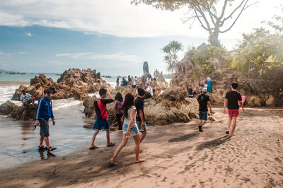 People at beach against sky