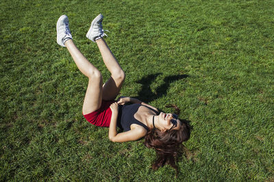 A young woman lying down on grass