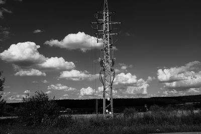 Electricity pylon on field against sky