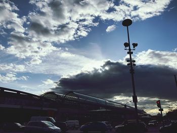 Low angle view of floodlight against cloudy sky