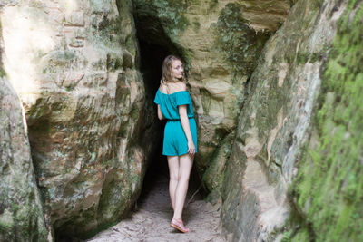 Full length portrait of woman standing in cave