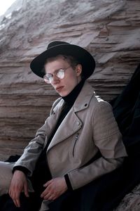 Portrait of young man wearing hat sitting outdoors