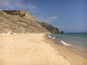 Scenic view of beach against blue sky