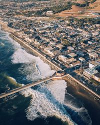 Aerial view of cityscape by sea during sunset