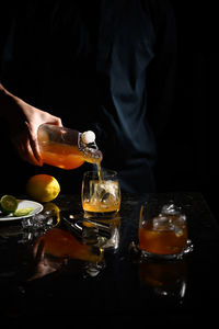 Midsection of man preparing food in glass on table