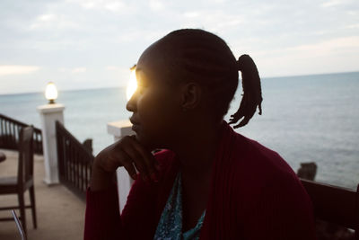 Woman looking away against sea