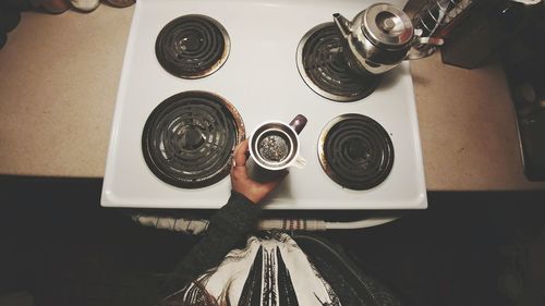 High angle view of human feet in kitchen