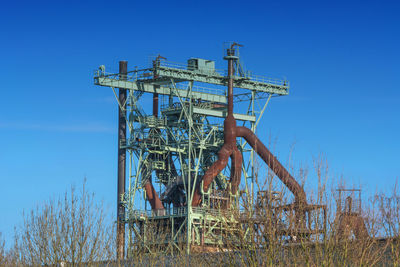 Cranes against clear blue sky