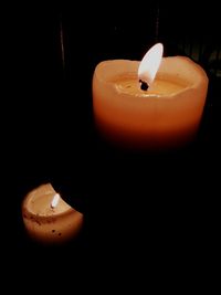 Close-up of illuminated candle in darkroom