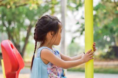 Side view of woman holding girl outdoors