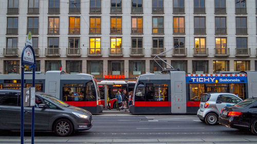 Vehicles on road by buildings in city