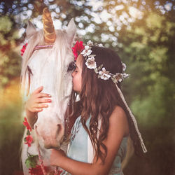 Teenage girl kissing white horse