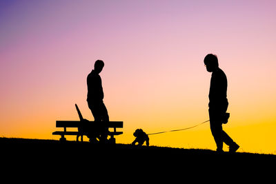 Low angle view of silhouette man standing against sky during sunset