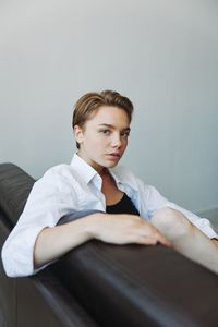 Portrait of young man standing against wall