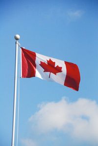 Low angle view of flag against blue sky