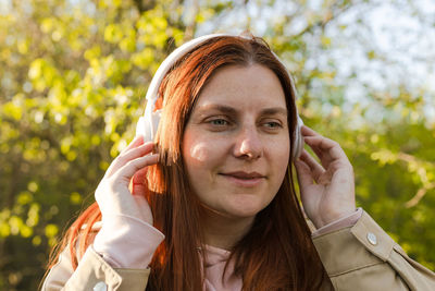 Close-up of woman wearing headphones outdoors