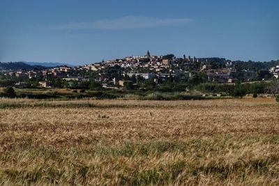 Scenic view of old houses on field against sky