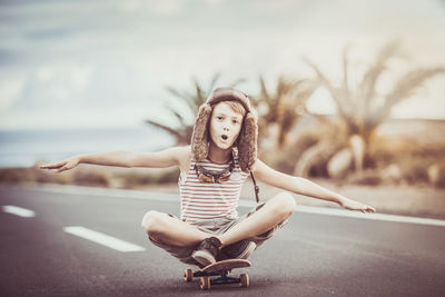 Portrait of young woman sitting on road