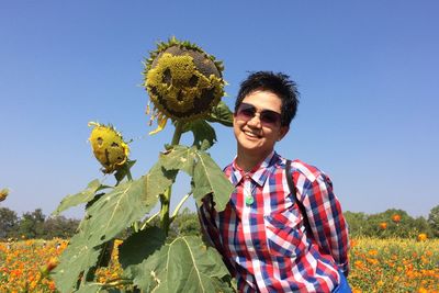 Portrait of smiling young man against blue sky