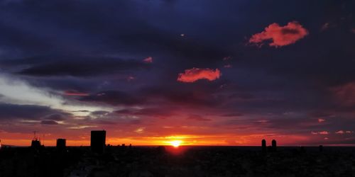 Scenic view of silhouette buildings against sky during sunset