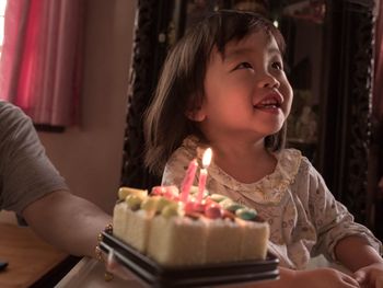 Cropped hand of father holding cake by cute girl