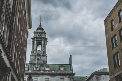 Low angle view of buildings against cloudy sky