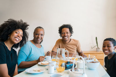 Portrait of happy friends sitting on table