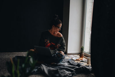 Woman looking away while sitting at home