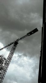 Low angle view of cranes against sky