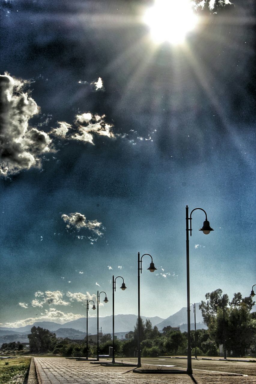 sun, sky, street light, sunbeam, sunlight, lens flare, road, tree, cloud - sky, transportation, tranquility, nature, the way forward, sunny, tranquil scene, landscape, street, beauty in nature, blue, cloud