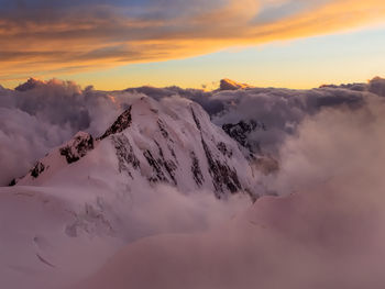 Scenic view of snow covered mountains against sky during sunset