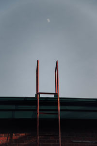 Ladder on building against sky