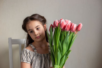 Girl with flowers sitting on chair