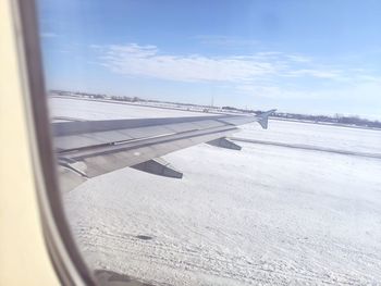 Airplane flying over snowcapped mountains against sky