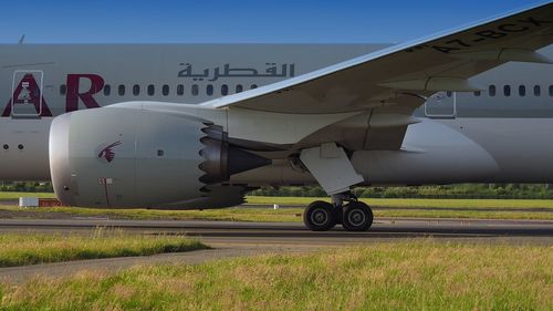 Airplane on airport runway against sky