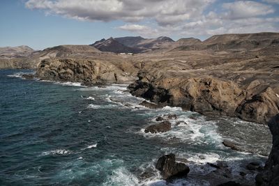 Scenic view of sea and mountains against sky