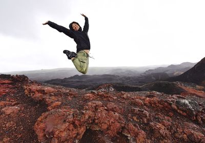 Full length of woman jumping in sky