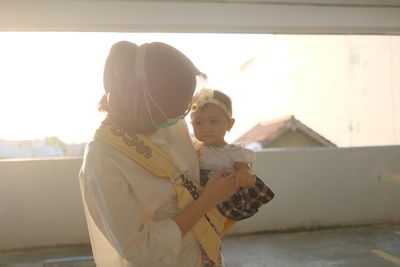 A young woman play with his baby girl 