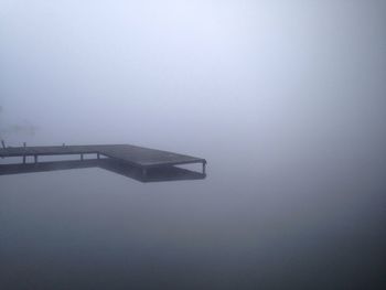 Jetty over lake during foggy weather