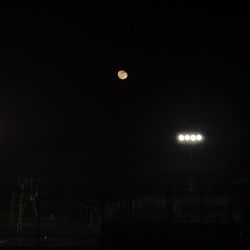 Low angle view of illuminated moon against sky at night