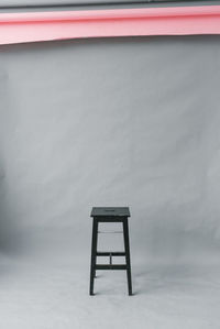 Black stool stool on a gray paper background in a photo studio