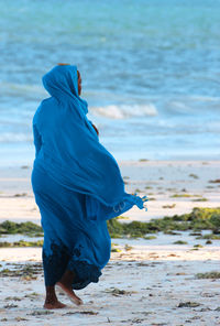 Rear view of woman standing on beach