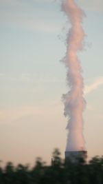 Smoke emitting from chimney against sky at sunset
