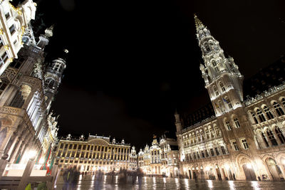 Low angle view of illuminated buildings against sky at night