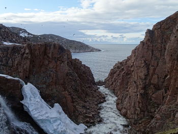 Scenic view of sea and mountains against sky