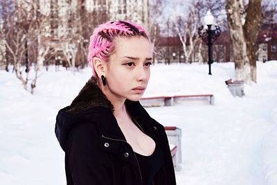 Young woman standing on snow covered road