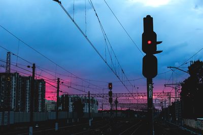 Silhouette railroad tracks against sky during sunset