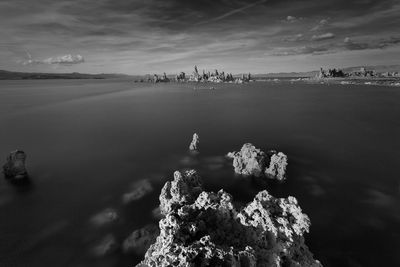 Idyllic shot of rock formations in mono lake against sky