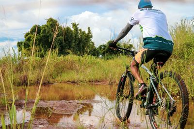 Man riding bicycle by lake